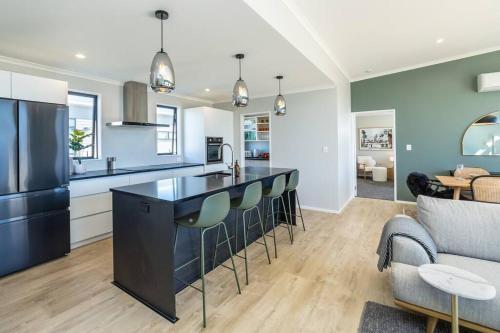 a kitchen and living room with a bar and a couch at Sunset On Syrah in Martinborough 