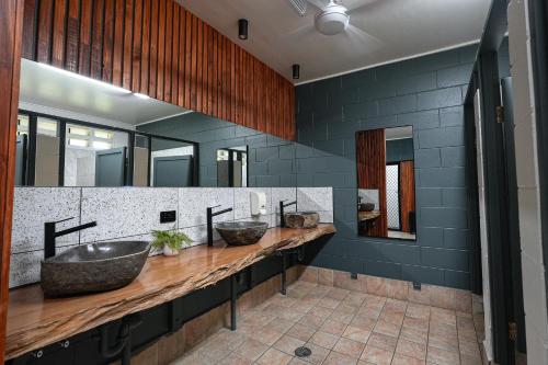 a bathroom with two sinks and a large mirror at Daintree Beach Resort in Wonga