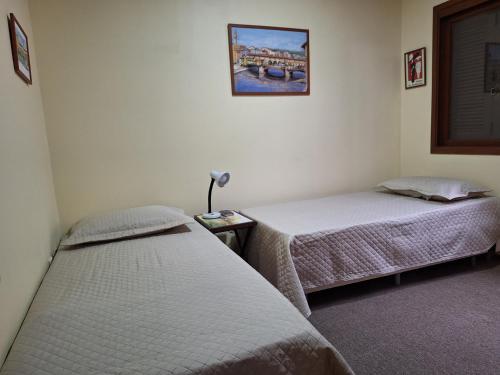 a room with two beds and a lamp in it at Apto 104 in Gramado