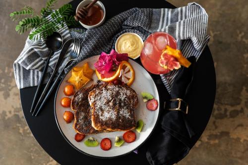 a plate of food with steak and fruit on a table at La Prometida in Puerto Viejo