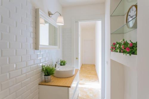een witte badkamer met een wastafel en een spiegel bij TownHouse by the Spanish Steps in Rome