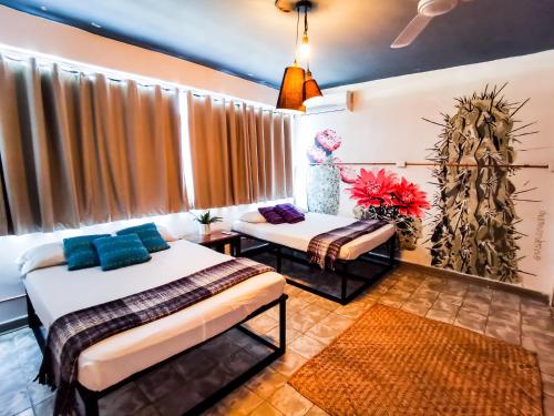 a bedroom with two beds and a window at Hostal Casa Los Abuelos in Cuatrociénegas de Carranza
