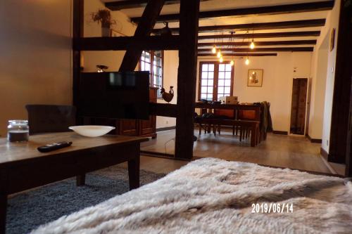 - un salon avec un lit, une table et une télévision dans l'établissement Duplex Saint Lustre, view over castle and storks, 5 mn from Colmar, à Eguisheim