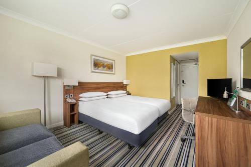 a hotel room with a bed and a couch at Holiday Inn Norwich, Ipswich Road by IHG in Norwich