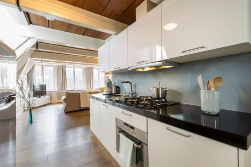 a kitchen with white cabinets and a black counter top at Grand Canal Boutique Hotel in Amsterdam