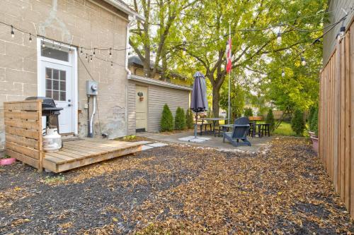 a patio with a table and an umbrella next to a house at Historic Home in the Heart of Elora in Elora