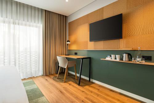 a room with a table and a television on a wall at Holiday Inn Beja by IHG in Beja