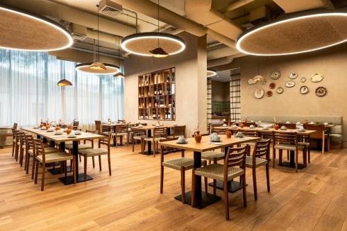 a restaurant with wooden tables and chairs and windows at Holiday Inn Beja by IHG in Beja