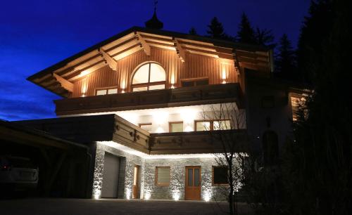 een huis verlicht in de nacht met lichten bij Chalet Findeisen in Ramsau am Dachstein