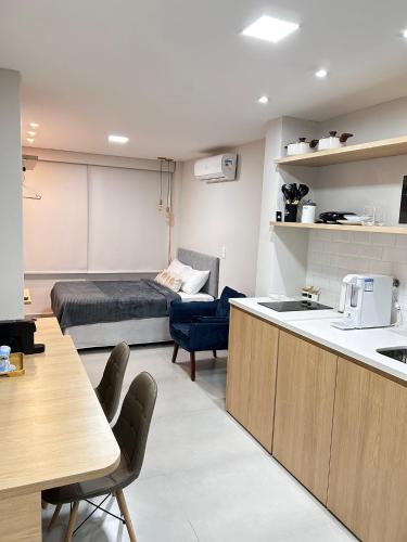 a kitchen and living room with a bed in a room at Studio Pé na areia - Icaraí in Niterói