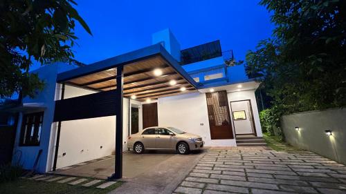 a car parked in a parking lot in front of a house at Boutique by Sa in Anuradhapura