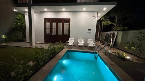 a swimming pool in front of a house at night at Boutique by Sa in Anuradhapura