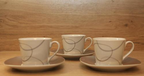 two coffee cups sitting on saucers on a table at Chalet Findeisen in Ramsau am Dachstein