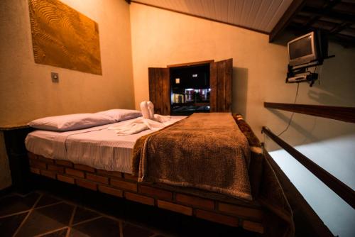 a bedroom with a bed with a blanket on it at Pousada Ranchico in Brumadinho