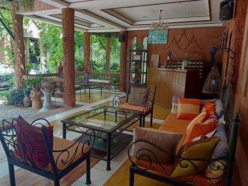 a living room with a couch and a table at Insda Wellness Resort in Chiang Mai