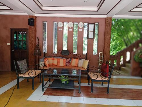 a living room with a couch and a table at Insda Wellness Resort in Chiang Mai