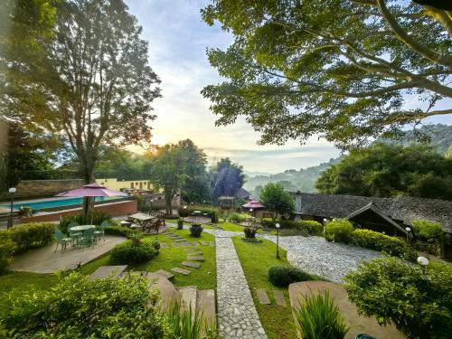 an image of a garden with tables and chairs at Insda Wellness Resort in Chiang Mai
