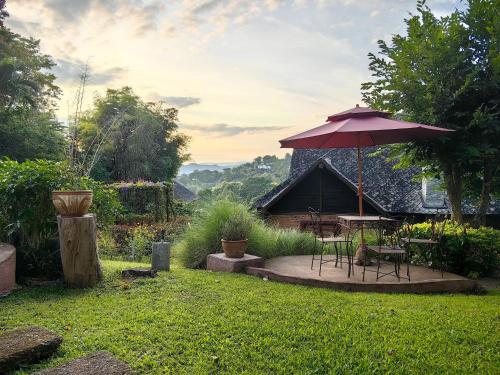 a patio with a table and an umbrella at Insda Wellness Resort in Chiang Mai