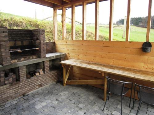 a porch with a wooden bench and a fireplace at Lovely house with much luxury and comfort in Waimes