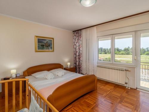 a bedroom with a bed and a large window at Family friendly house with a swimming pool Jadranovo, Crikvenica - 22273 in Jadranovo