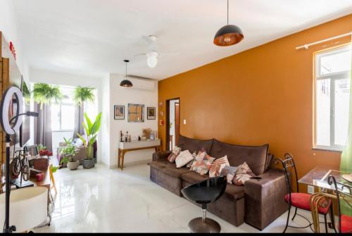 een woonkamer met een bruine leren bank bij Quarto com Anfitrião RJ in Rio de Janeiro