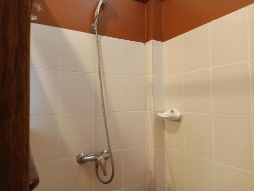 a shower in a bathroom with white tiles at Insda Wellness Resort in Chiang Mai
