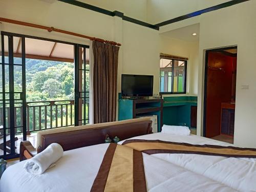 a bedroom with two beds and a balcony at Insda Wellness Resort in Chiang Mai