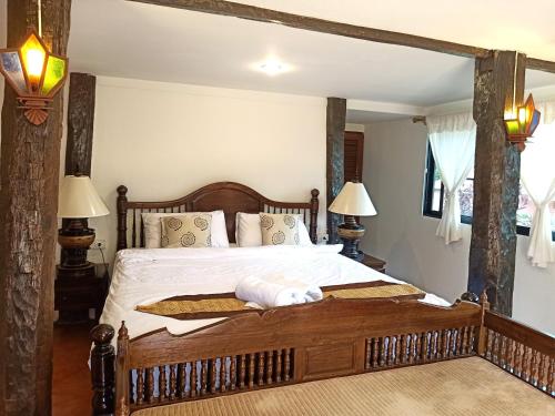 a bedroom with a large bed with a wooden frame at Insda Wellness Resort in Chiang Mai