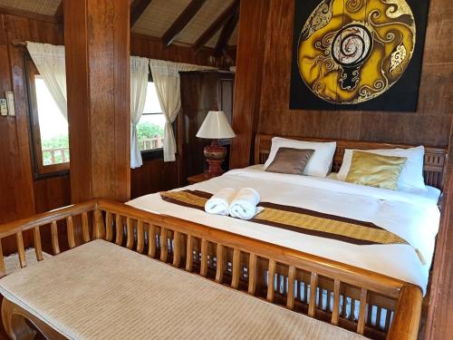 a bedroom with a bed with two towels on it at Insda Wellness Resort in Chiang Mai