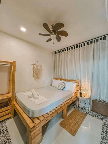 a bed in a room with a ceiling fan at Michel'inn Coron in Coron