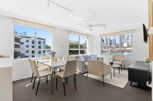 a dining room with a table and chairs and windows at Sydney Harbourside Apartment in Sydney