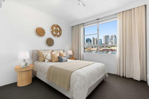 a bedroom with a bed and a large window at Sydney Harbourside Apartment in Sydney
