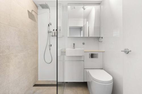 a bathroom with a toilet and a sink and a shower at Sydney Harbourside Apartment in Sydney