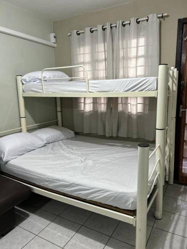 two bunk beds in a room with a window at Kitnet Flamingo 31B in Matinhos