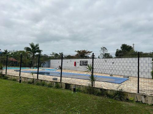 a fence in front of a swimming pool at Kitnet Flamingo 31B in Matinhos