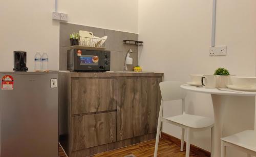 a kitchen with a counter with a microwave and a refrigerator at K Avenue Modern Style Studio (5 Mins to Airport) in Kota Kinabalu