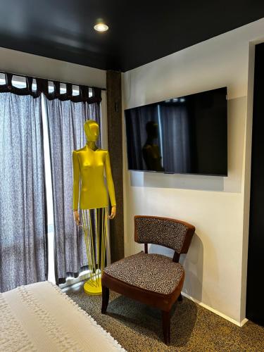 a mannequin and a chair in a room with a television at The Hawthorne in Brisbane