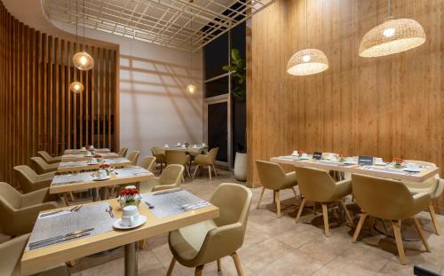a restaurant with wooden walls and tables and chairs at Holiday Inn Bogota Airport by IHG in Bogotá