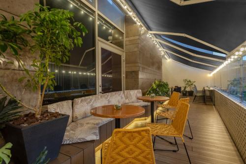a restaurant with tables and chairs and plants at Holiday Inn Bogota Airport by IHG in Bogotá