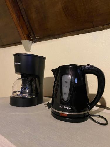 a black appliance sitting on a counter next to a blender at Cabañita del bosque de la cumbre de san Bartolo Milpas Altas in Guatemala