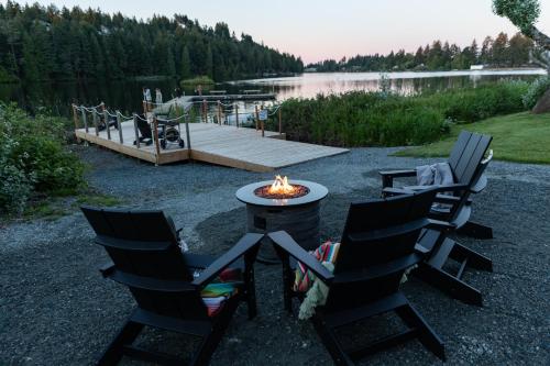 a fire pit with chairs and a table and a dock at Inn on Long Lake in Nanaimo