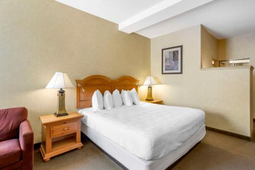 a bedroom with a large white bed and a couch at Best Western PLUS Revere Inn & Suites in Paradise