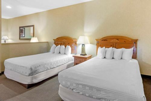 a hotel room with two beds and a mirror at Best Western PLUS Revere Inn & Suites in Paradise