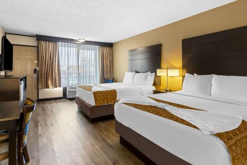 a hotel room with two beds and a flat screen tv at Best Western Toni Inn in Pigeon Forge