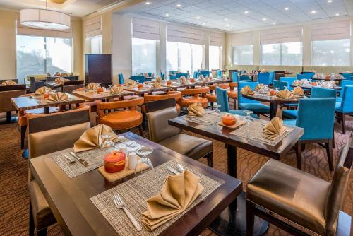 a restaurant with wooden tables and blue chairs at Hilton Garden Inn Florence in Florence