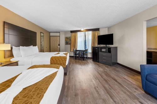 a hotel room with two beds and a flat screen tv at Best Western Toni Inn in Pigeon Forge