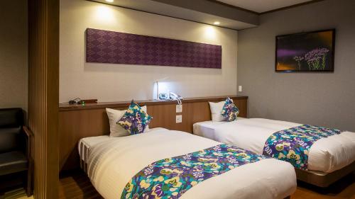 a hotel room with two beds in a room at Hanare no yado Kamigakure in Takachiho