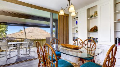 a dining room with a glass table and chairs at Maui Eldorado D200 - 2 Bedroom in Lahaina