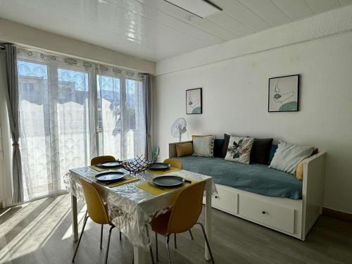 un salon avec un canapé et une table avec des chaises dans l'établissement Appartement cosy 2 pièces, 4 pers, plage à 100m, clim, balcon, animaux admis - FR-1-225-824, à Argelès-sur-Mer