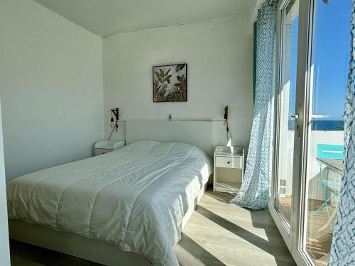 une chambre blanche avec un lit et une grande fenêtre dans l'établissement Appartement cosy 2 pièces, 4 pers, plage à 100m, clim, balcon, animaux admis - FR-1-225-824, à Argelès-sur-Mer